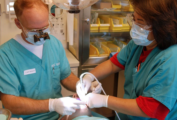 Dental assistant assisting a dentist with a patient