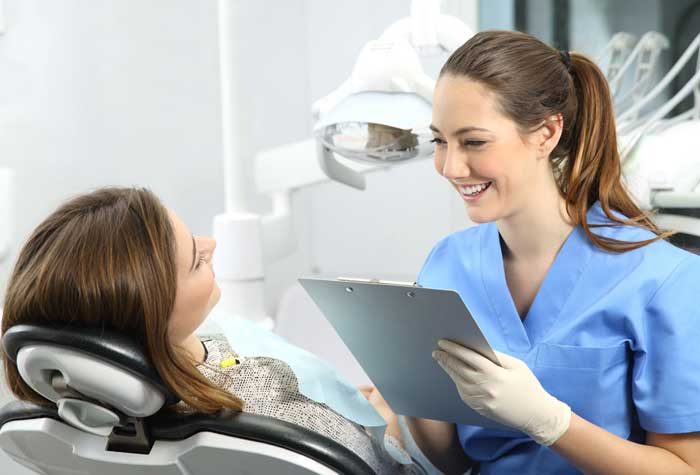 Dental assistant in an office smiling with patient