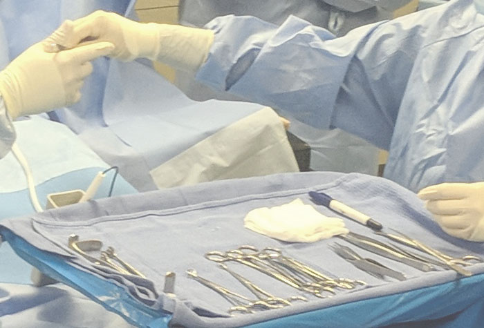 Surgeons and Surgical Techs in the Operating Room handing tools to each other
