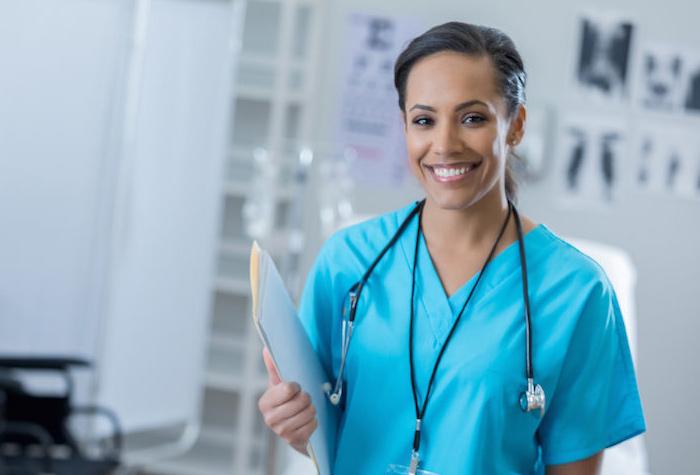 Medical Assistant smiling at camera while holding a file