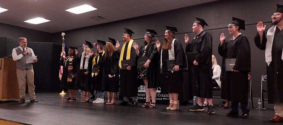 Veterinary Technician students with hands raised taking their oaths at graduation ceremony
