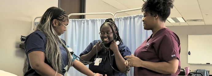 Medical Assistant students practicing taking blood pressure with milwaukee career college instructor