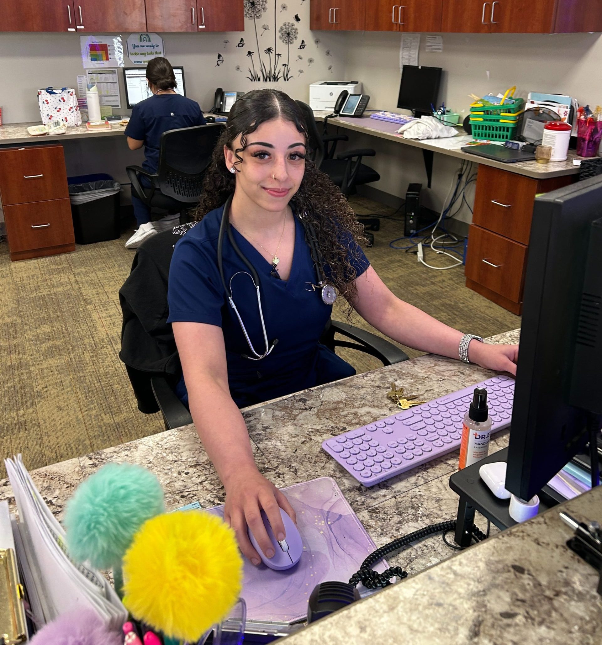 Dental assistant student sitting at receptionist desk at dental practice