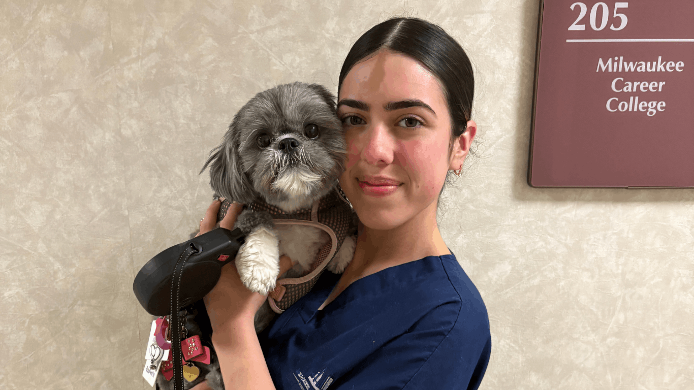 Female vet student holding small dog